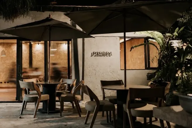 Madera, piedra y una terraza bajo los árboles